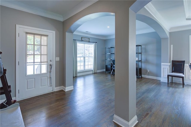 foyer featuring arched walkways, dark wood-style floors, ornamental molding, and baseboards