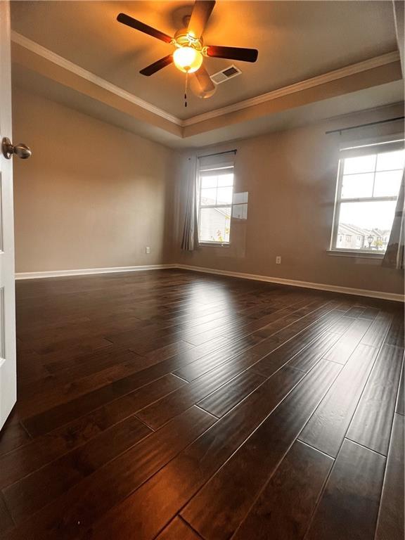 2778 Wild Laurel Ct, Norcross, GA 30071 - unfurnished room with a raised ceiling, crown molding, dark wood-style flooring, ceiling fan, and baseboards