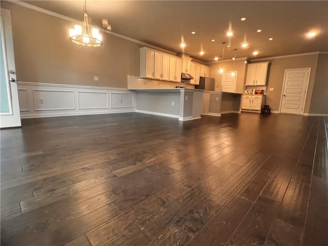 2778 Wild Laurel Ct, Norcross, GA 30071 - unfurnished living room with crown molding, dark wood-style floors, a chandelier, a wainscoted wall, and recessed lighting