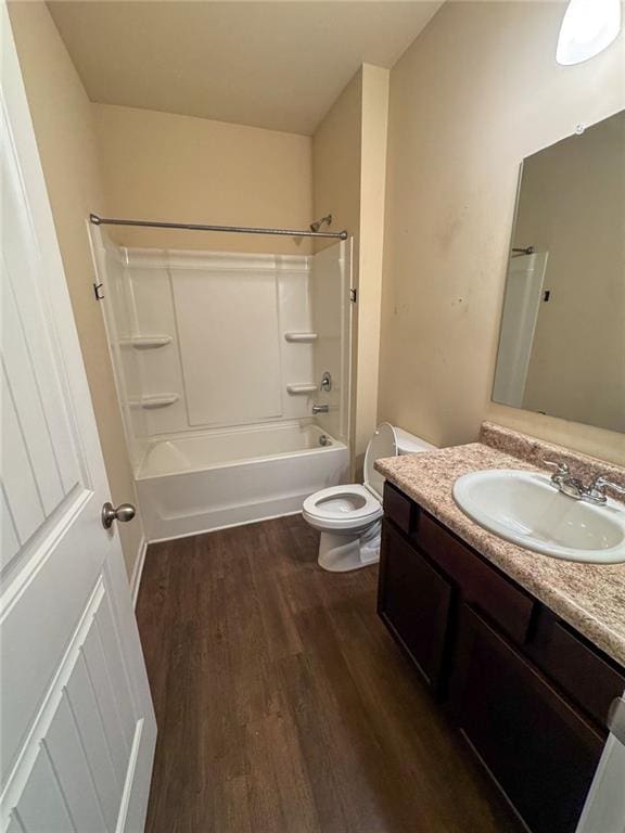 bathroom featuring vanity, tub / shower combination, wood finished floors, and toilet