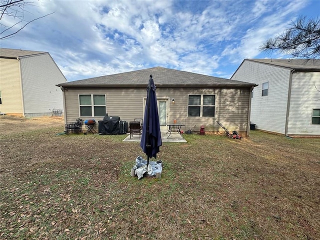 back of house featuring a patio area and a lawn