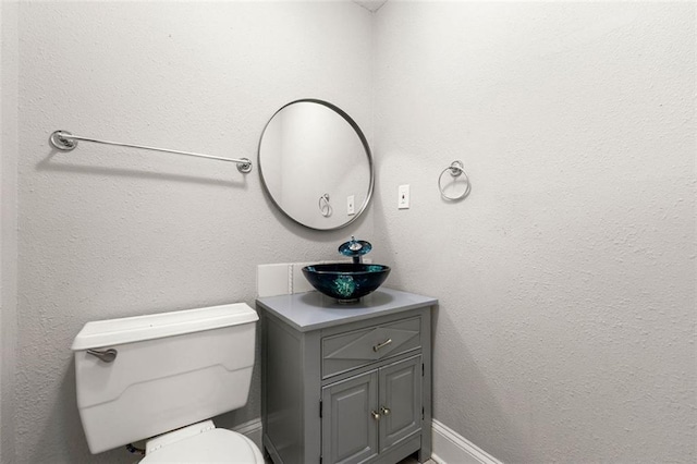 bathroom featuring vanity, toilet, and baseboards