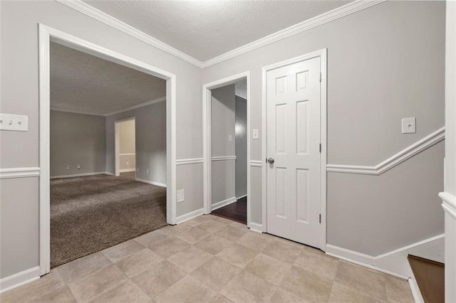 unfurnished room featuring a textured ceiling, crown molding, stairs, and baseboards