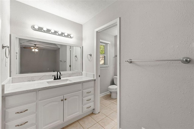 bathroom with tile patterned floors, ceiling fan, vanity, toilet, and a textured ceiling