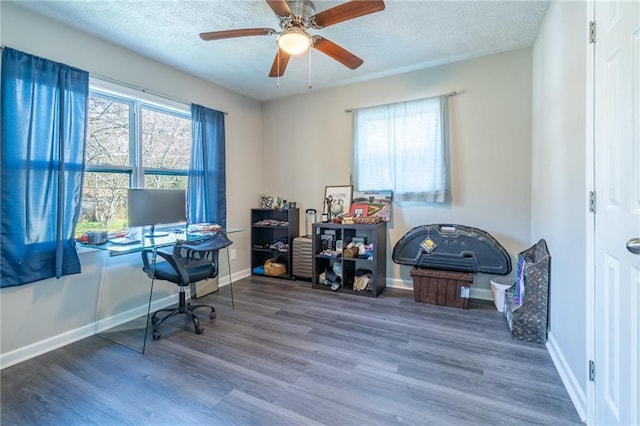 office area with ceiling fan, a textured ceiling, baseboards, and wood finished floors