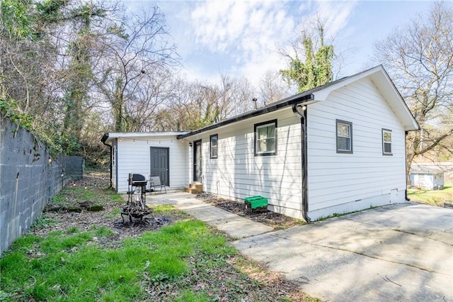 back of house featuring an outdoor structure and fence