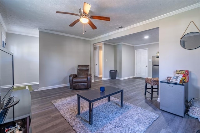 living area with a textured ceiling, wood finished floors, and baseboards