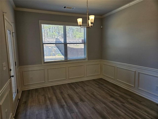 spare room featuring a wainscoted wall, a notable chandelier, visible vents, dark wood-type flooring, and ornamental molding