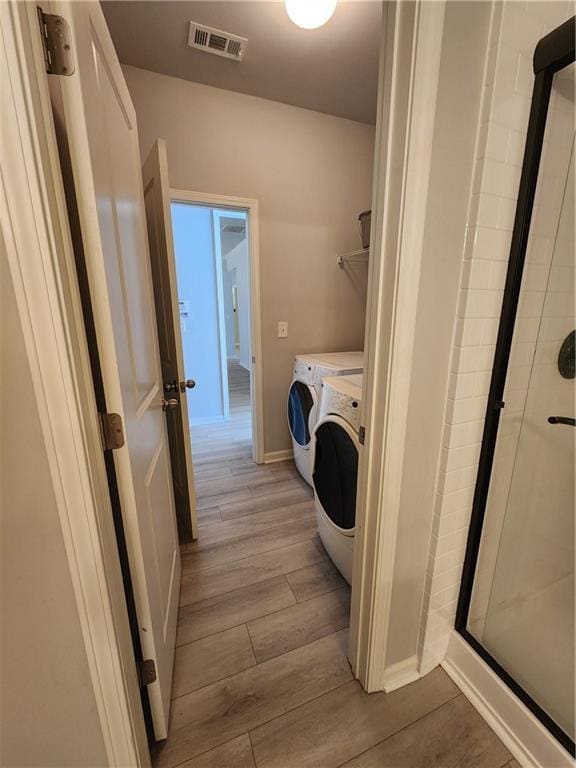 laundry room featuring laundry area, visible vents, baseboards, light wood-style floors, and independent washer and dryer