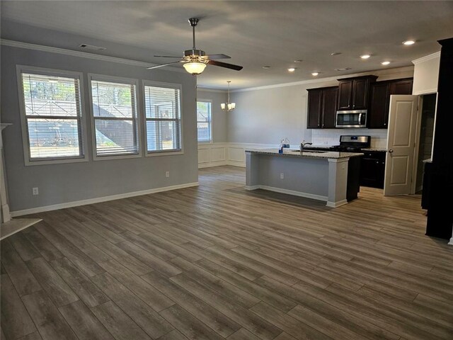 kitchen with open floor plan, appliances with stainless steel finishes, dark wood-type flooring, and ornamental molding