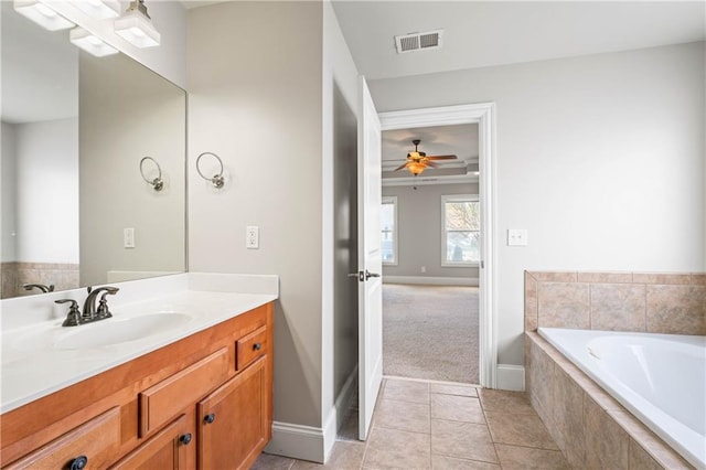 bathroom with tiled bath, baseboards, visible vents, tile patterned flooring, and vanity