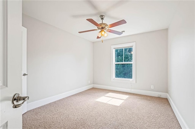 unfurnished room featuring carpet, visible vents, baseboards, and ceiling fan