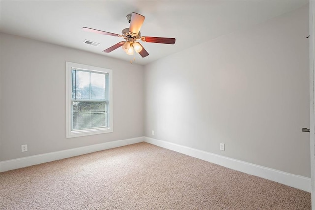 empty room featuring carpet, visible vents, and baseboards