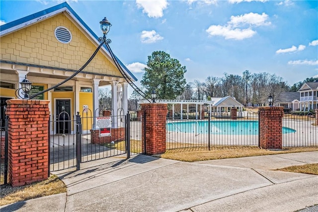 view of gate featuring fence and a community pool