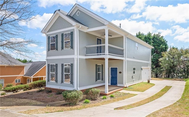 view of front of house with a garage, a ceiling fan, concrete driveway, a balcony, and a porch