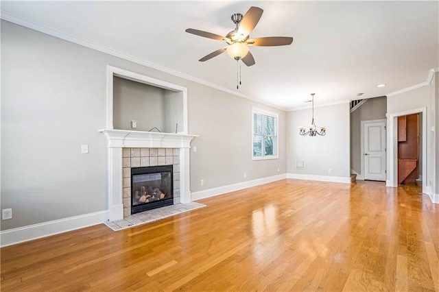 unfurnished living room featuring ornamental molding, light wood finished floors, and a tiled fireplace