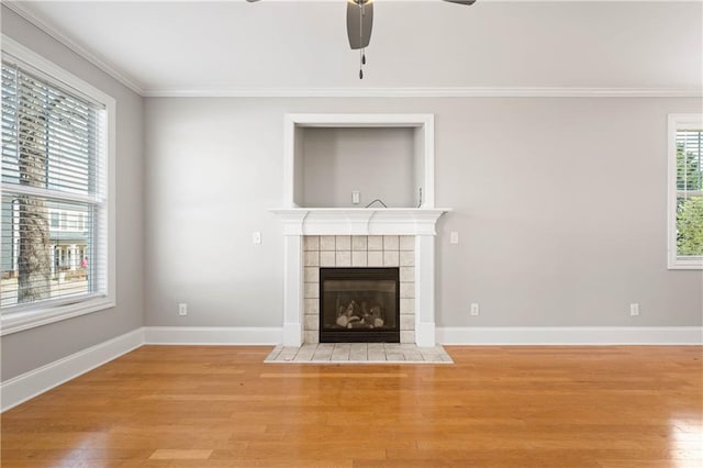 unfurnished living room with light wood finished floors, ornamental molding, and a fireplace