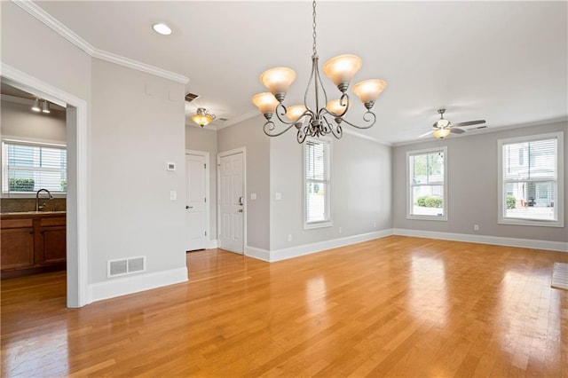 interior space with baseboards, light wood finished floors, visible vents, and crown molding