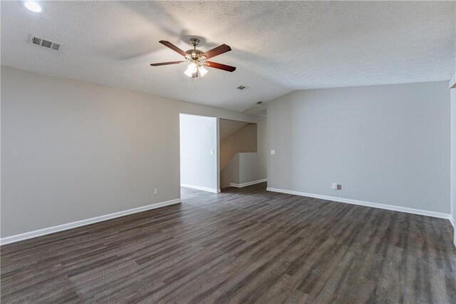 unfurnished room featuring ceiling fan, dark hardwood / wood-style floors, lofted ceiling, and a textured ceiling