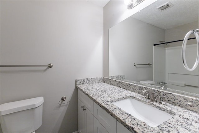 bathroom featuring vanity, toilet, and a shower