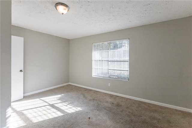 unfurnished room featuring a textured ceiling and light carpet