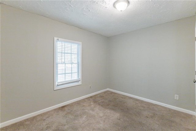 unfurnished room with light carpet and a textured ceiling