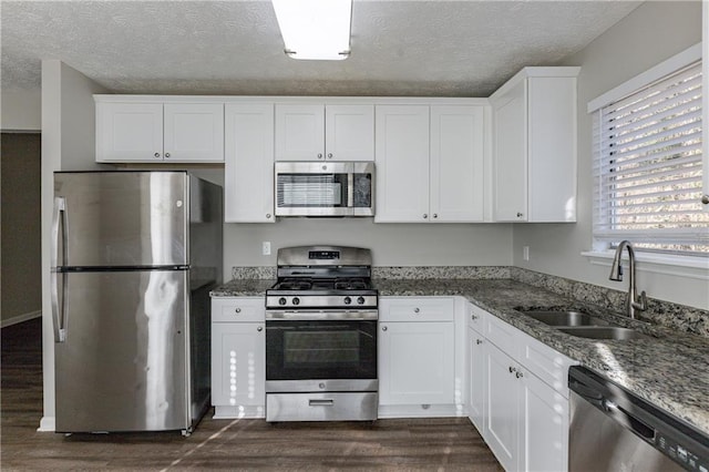 kitchen with sink, white cabinets, stone countertops, and appliances with stainless steel finishes