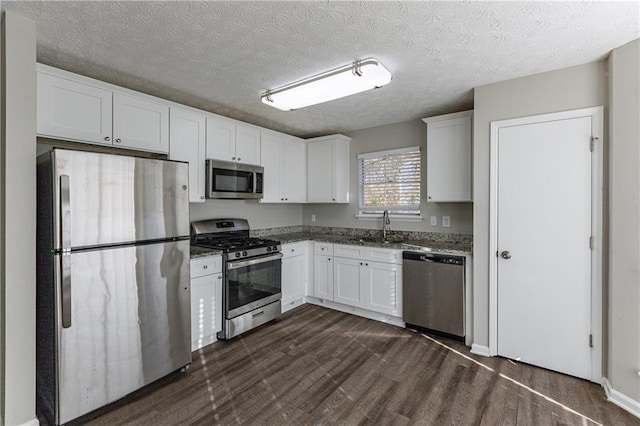 kitchen featuring light stone countertops, sink, white cabinets, and appliances with stainless steel finishes