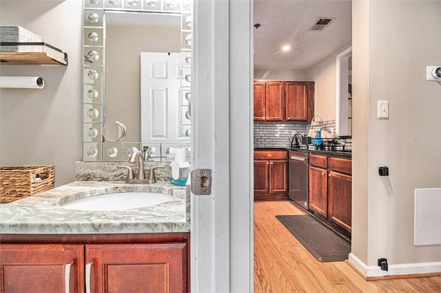 bathroom featuring tasteful backsplash, hardwood / wood-style flooring, and sink