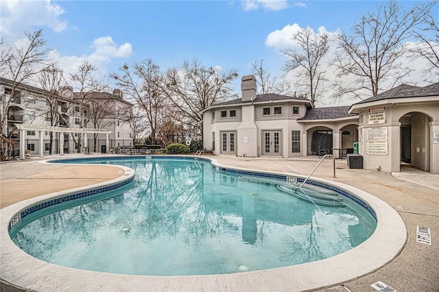 view of swimming pool featuring french doors and a patio area