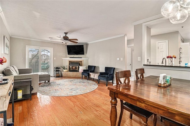 living room featuring ornamental molding, wood-type flooring, and ceiling fan