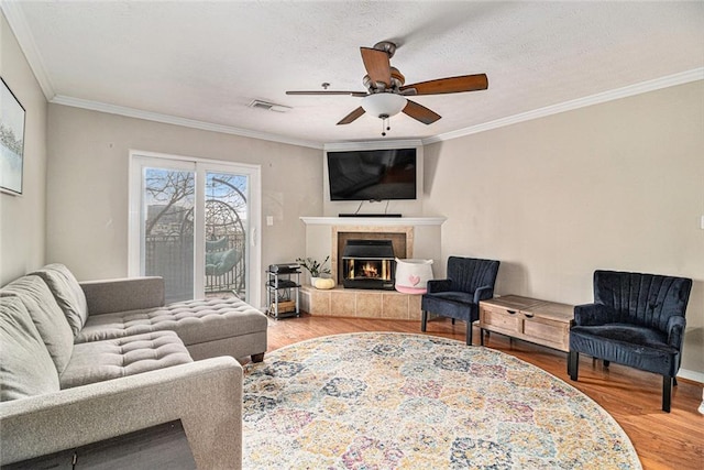 living room featuring hardwood / wood-style flooring, ornamental molding, and a fireplace