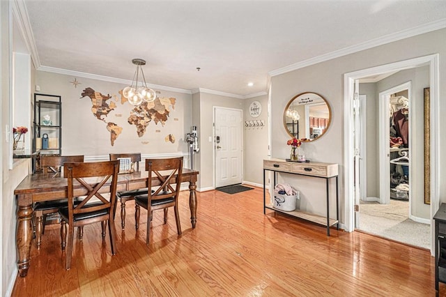 dining room with a notable chandelier, crown molding, and hardwood / wood-style flooring