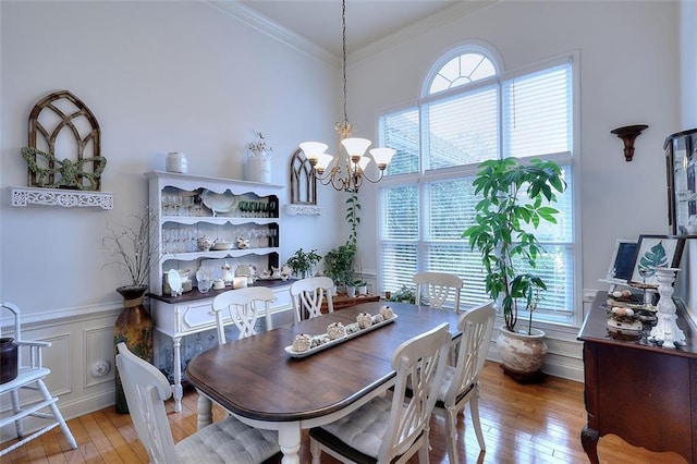 dining room featuring crown molding, an inviting chandelier, and light hardwood / wood-style flooring