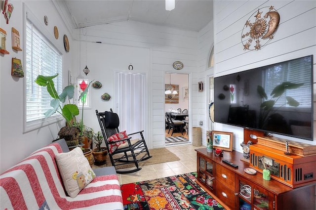 tiled living room with wood walls, ornamental molding, and lofted ceiling