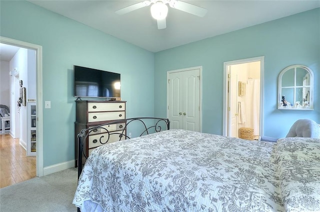 bedroom with light carpet, ceiling fan, a closet, and connected bathroom