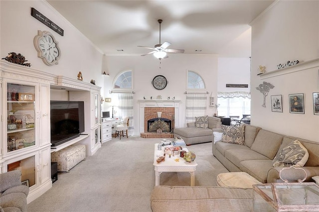 carpeted living room with a brick fireplace, a towering ceiling, and ceiling fan