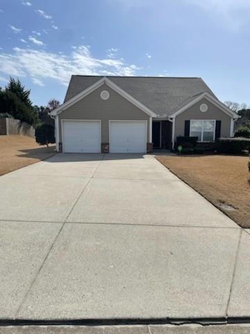 ranch-style home featuring an attached garage and driveway