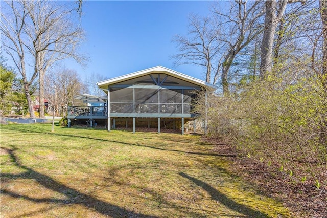 rear view of house featuring a lawn and a sunroom