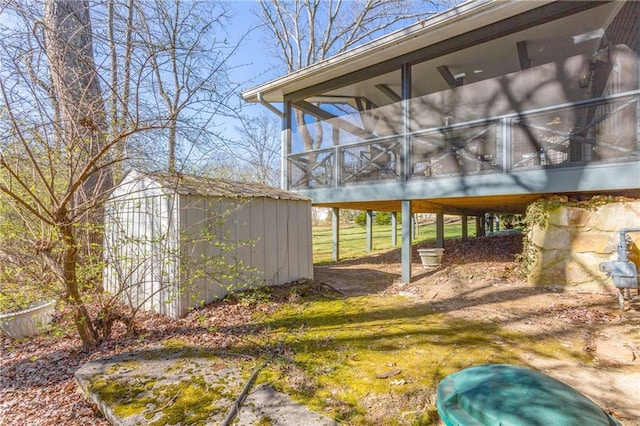 view of yard featuring a storage unit, an outdoor structure, and a sunroom