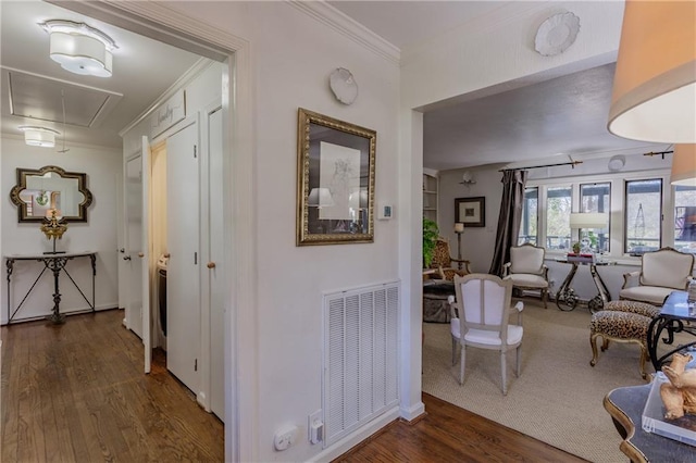 hall featuring attic access, crown molding, visible vents, and dark wood-type flooring