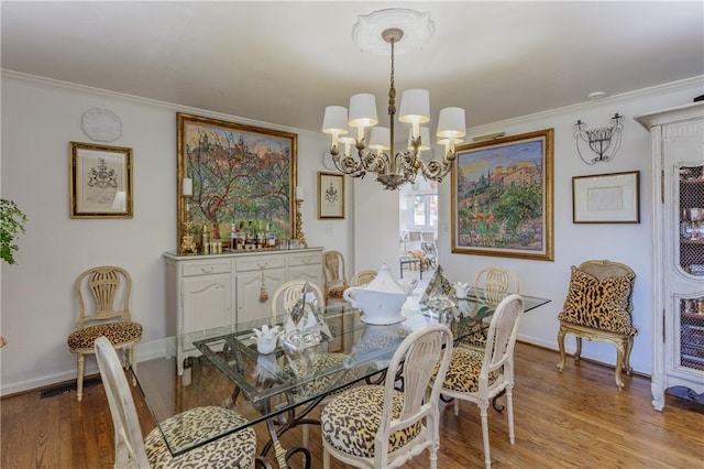 dining room with an inviting chandelier, wood finished floors, and ornamental molding