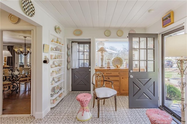 foyer entrance featuring a chandelier, wooden ceiling, and crown molding