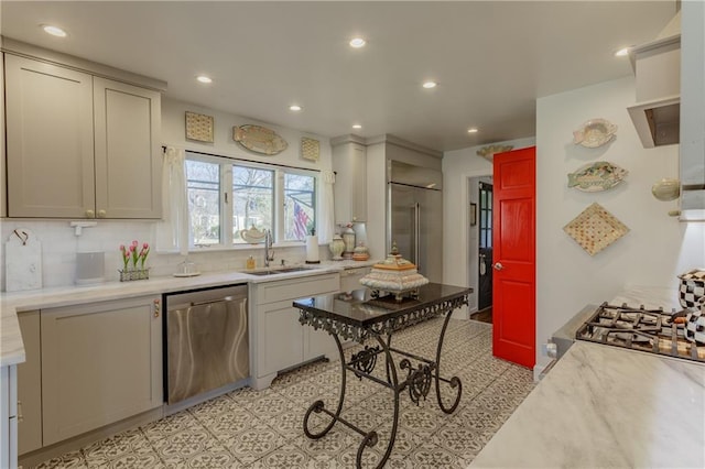 kitchen featuring a sink, recessed lighting, appliances with stainless steel finishes, light countertops, and decorative backsplash