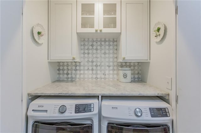 kitchen with glass insert cabinets, white cabinets, separate washer and dryer, and backsplash