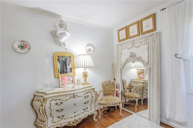 sitting room with wood finished floors and ornamental molding