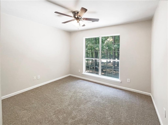 carpeted spare room featuring ceiling fan