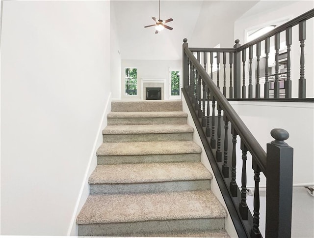 stairs with ceiling fan and a high ceiling