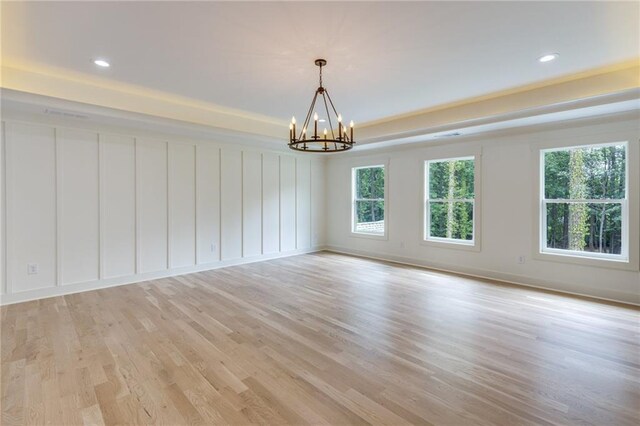 spare room with a chandelier and light hardwood / wood-style floors