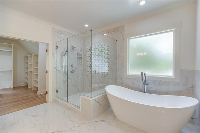 bathroom with plus walk in shower, hardwood / wood-style flooring, and ornamental molding